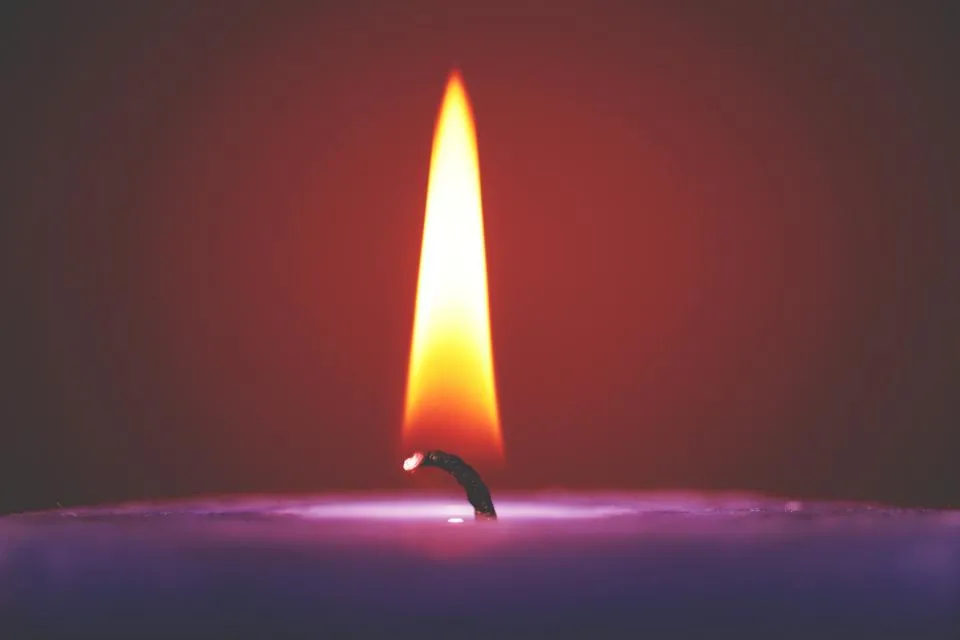La flamme d’une bougie dans une lumière rouge